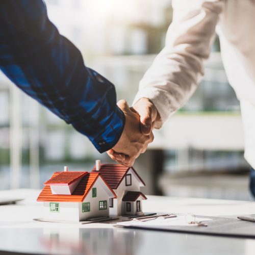 Real estate agents shake hands after the signing of the contract agreement is complete.